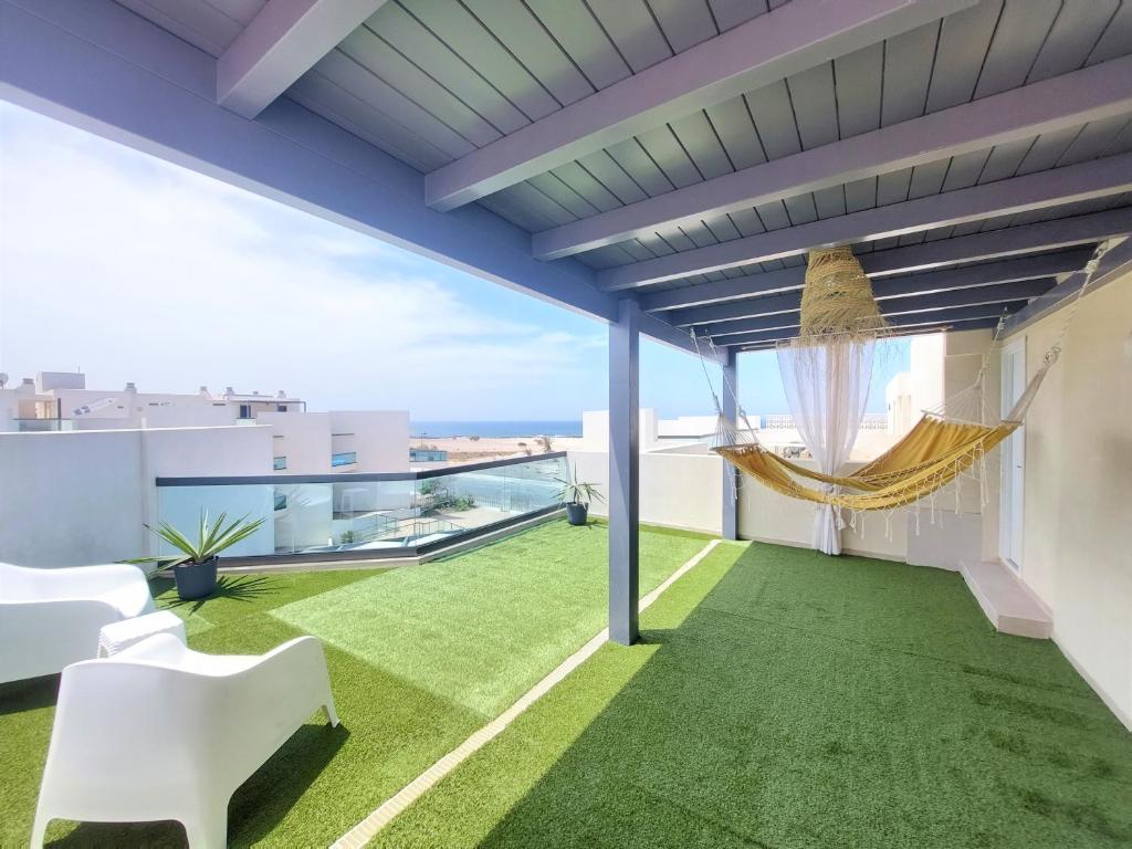 コティージョにあるDeep Blue Cotillo I by Sea You There Fuerteventuraの家屋の屋上にハンモック付きのパティオ