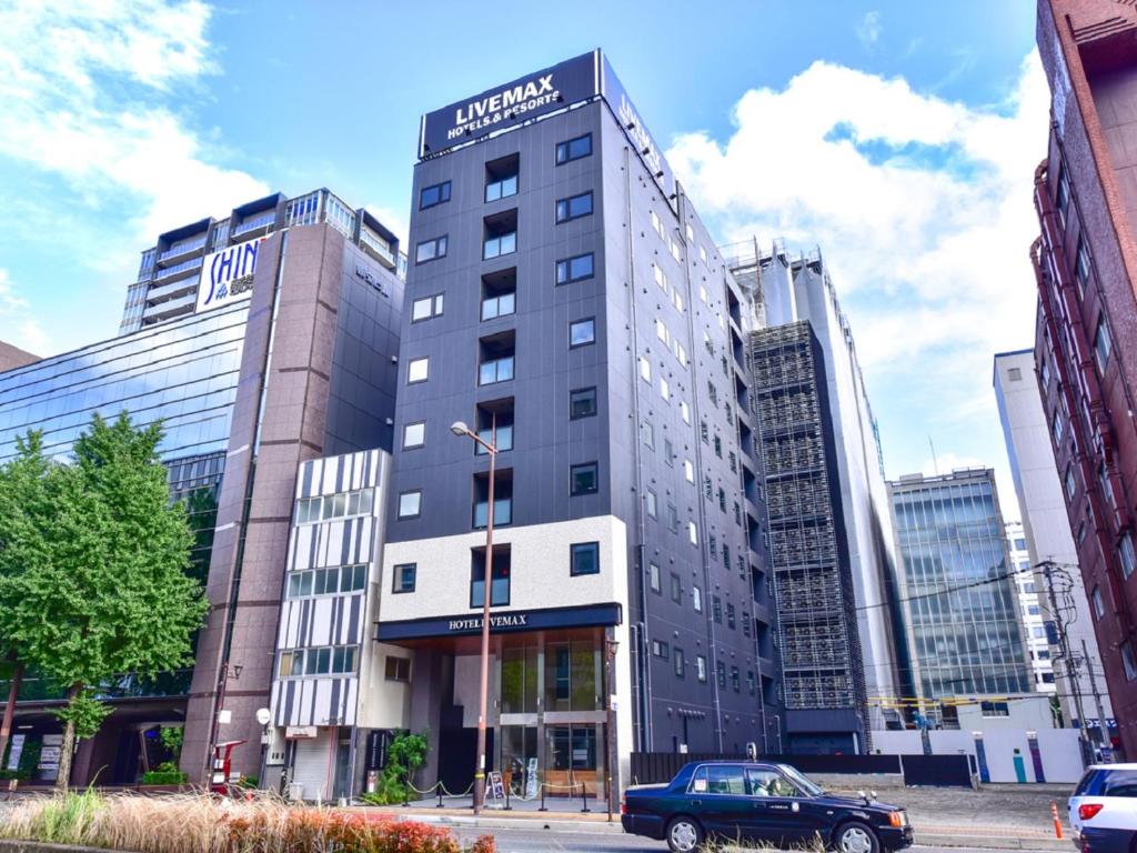福岡的住宿－HOTEL LiVEMAX Fukuoka Tenjin West，前面有停车位的建筑