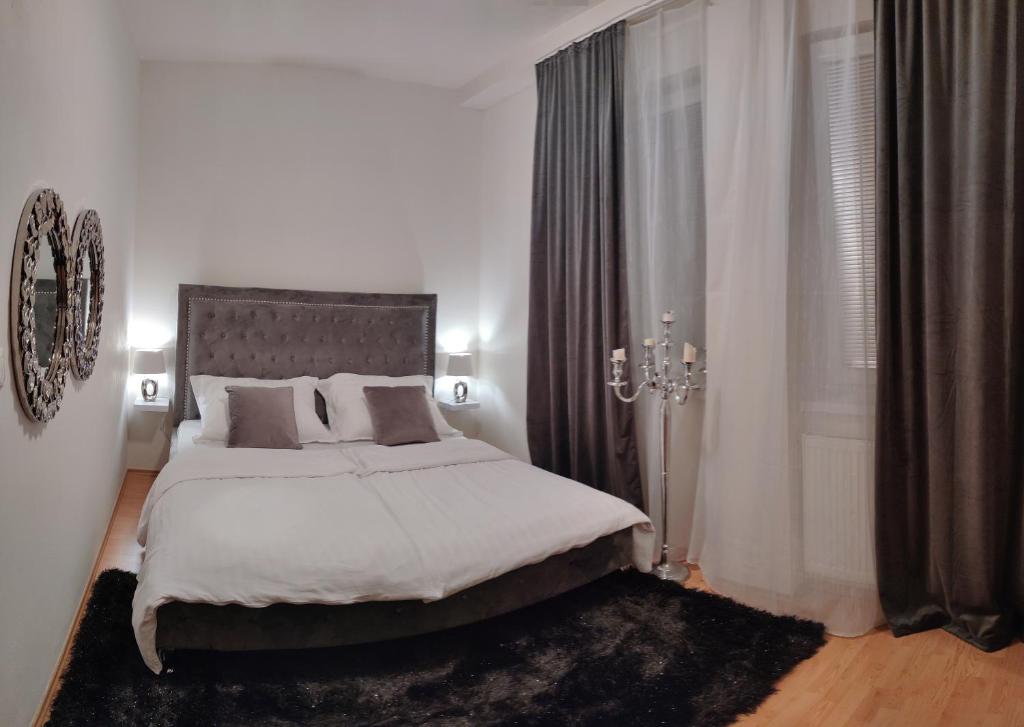 a white bedroom with a large bed and a window at 2 izbový byt 60m2 v centre na Bakossovej, 24h self checkin in Banská Bystrica