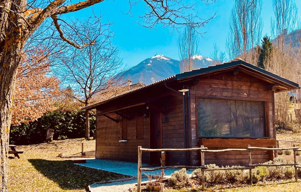 a small wooden cabin with a mountain in the background at Chalet Vacanze Il Daino in Leonessa