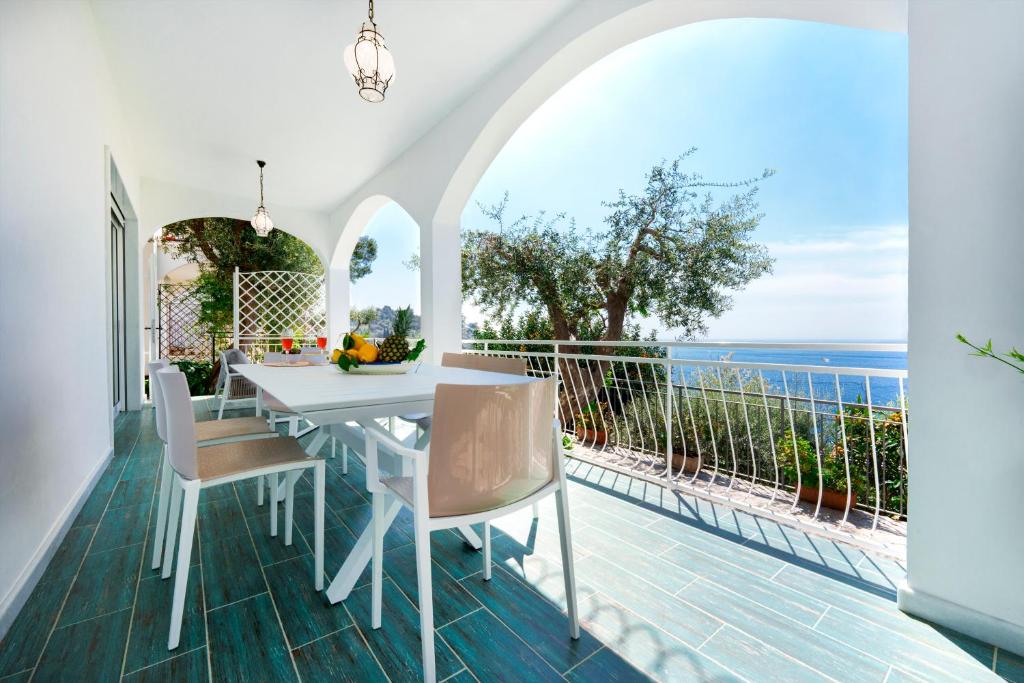 a white dining room with a view of the ocean at Incanto apartament stunning sea view in Nerano