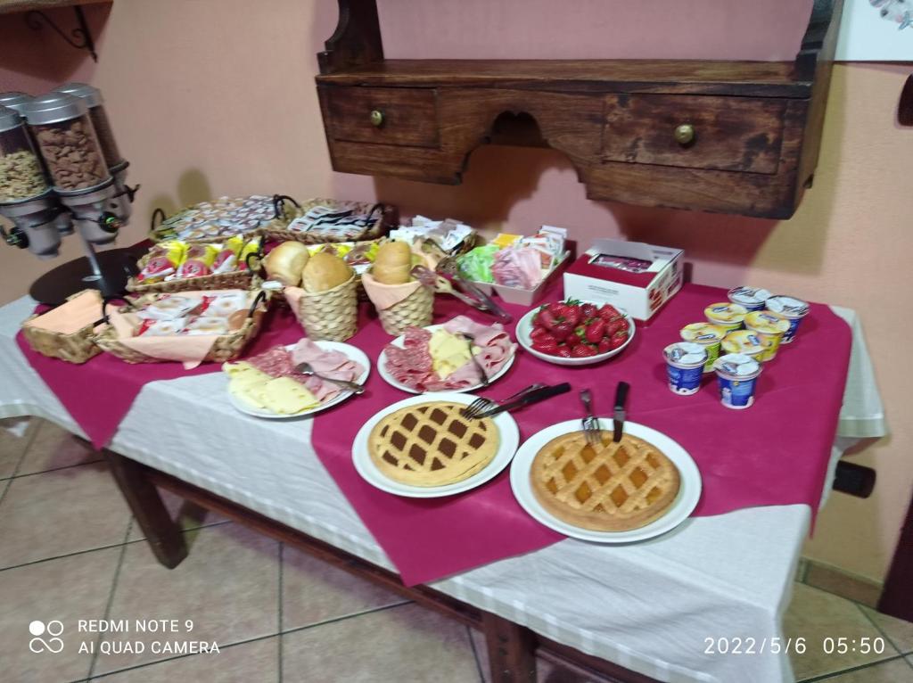 a table with plates of food and waffles on it at fell hotel in Susa