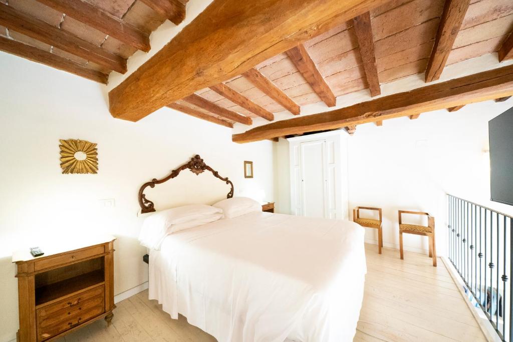 a bedroom with a white bed and wooden ceilings at Le Stanze di Galileo in Perugia