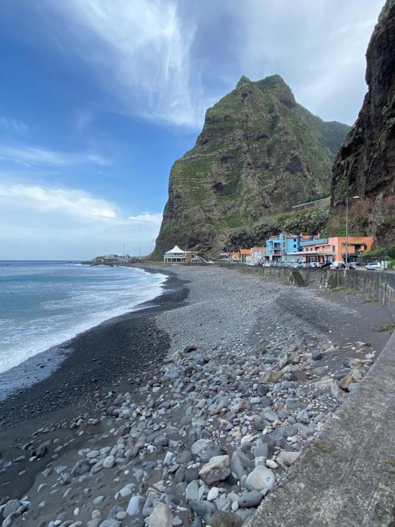 uma praia rochosa com uma montanha ao fundo em ᴠɪʟʟᴀɢᴇ ʜᴏᴜsᴇ em São Vicente