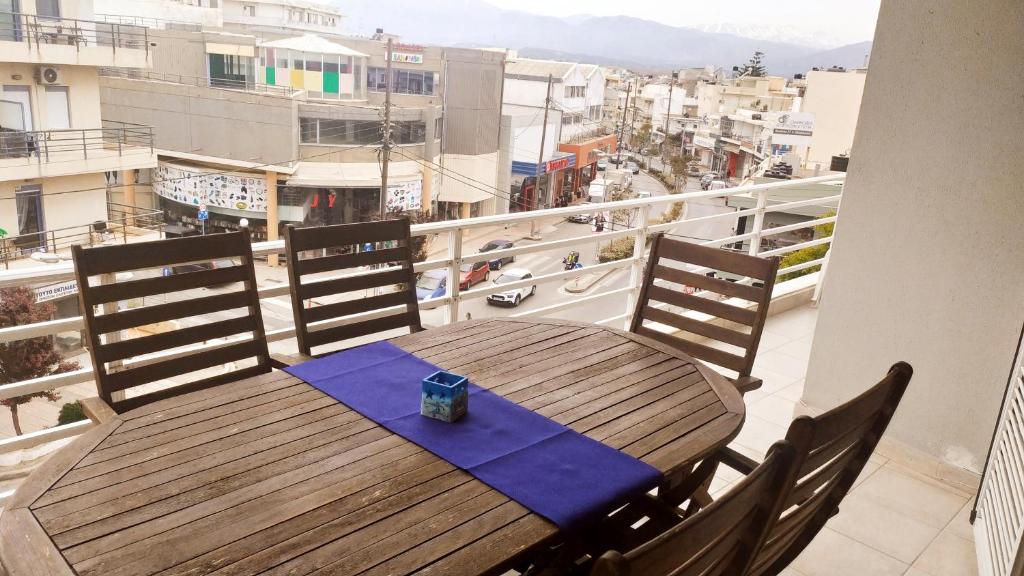 een houten tafel en stoelen op een balkon bij Appartement Heraklion - Vue mer et montagne in Heraklion