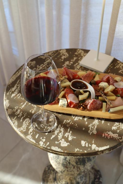 a plate of food and a glass of wine at Hotel Villa Pascucci in Durrës