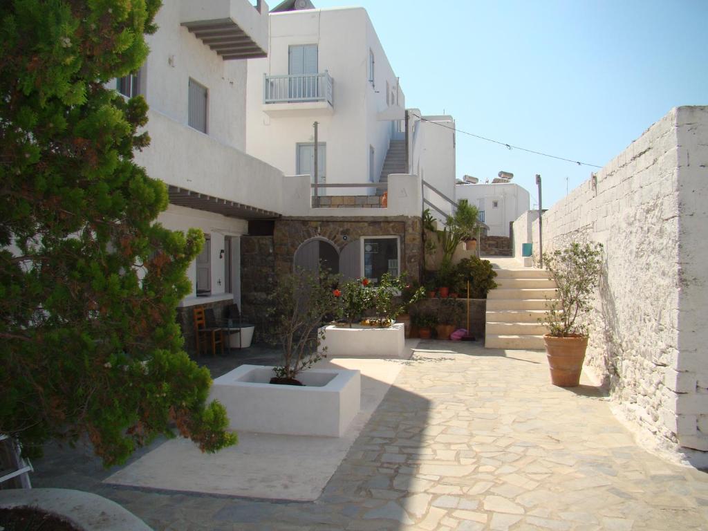 a building with a courtyard with potted plants on it at Manos Rooms in Mýkonos City