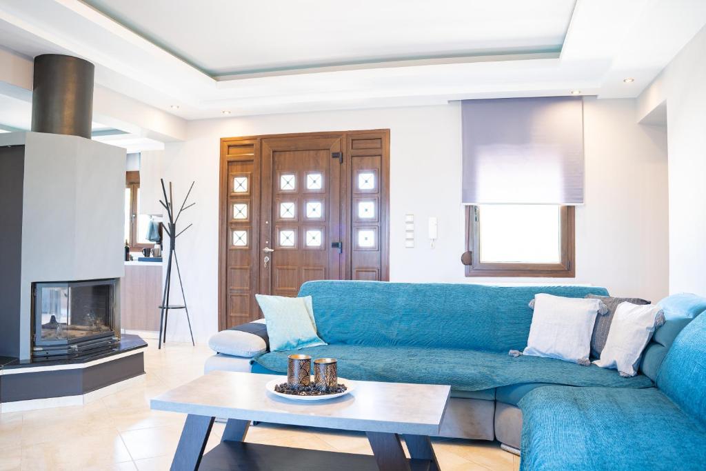 een woonkamer met een blauwe bank en een tafel bij Luxury Apartments in Platánion