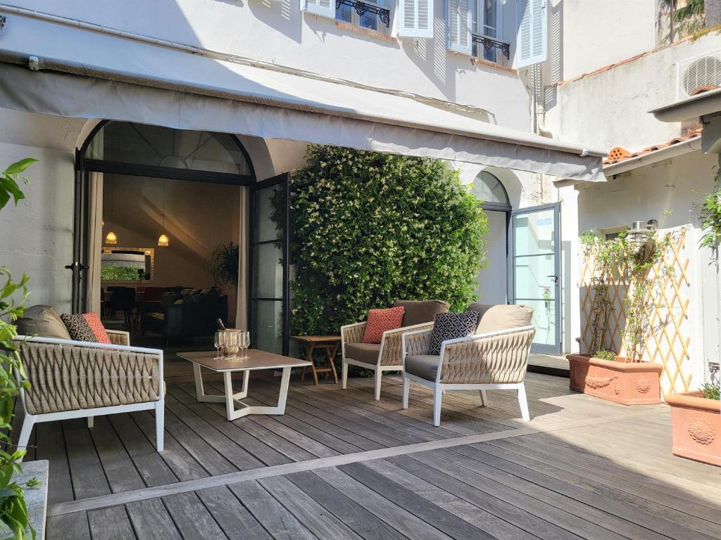 eine Außenterrasse mit Stühlen und einem Tisch in der Unterkunft Villa Terra by Festif Azur - House 250m2 Quiet, 5 min walk from Palais des Festivals and Beaches in Cannes