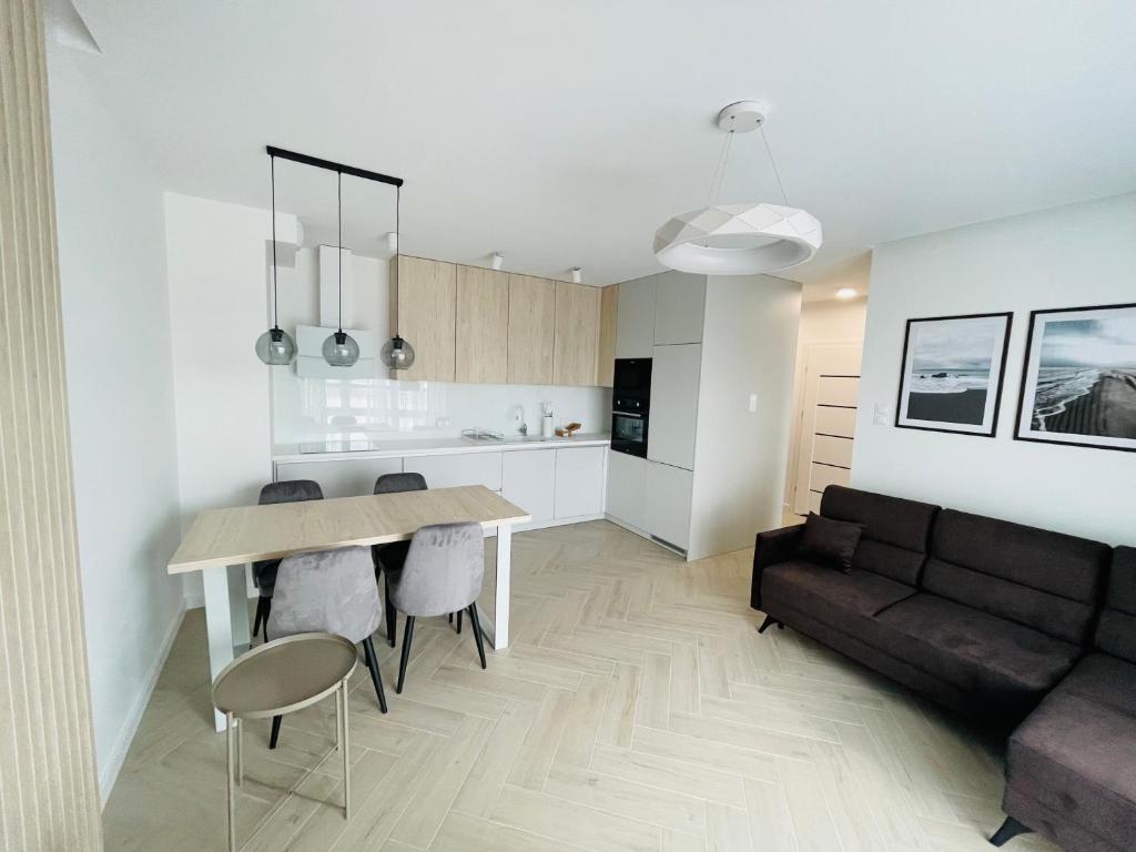 een keuken en een woonkamer met een tafel en een bank bij Apartamenty Plaza Tower in Kielce