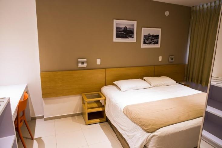 a small bedroom with a bed and a small table at Atlantis Copacabana Hotel in Rio de Janeiro