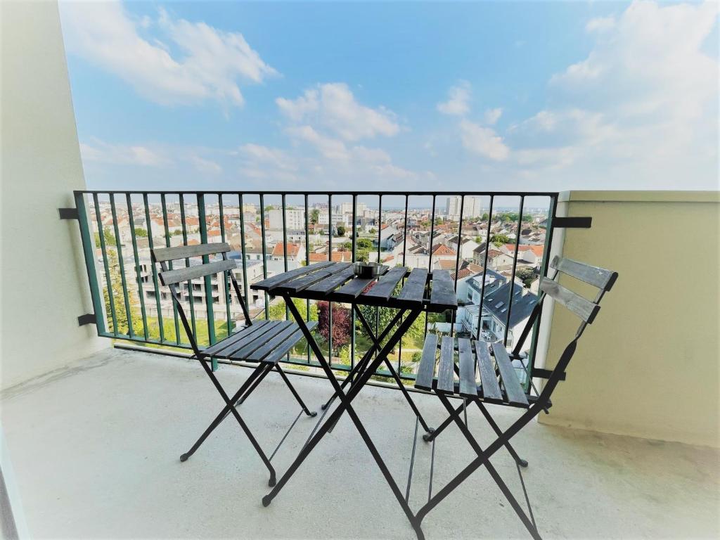 a table and two chairs on a balcony at BROSSOLETTE Appartement T2 spacieux et lumineux balcon vue dégagée in Reims