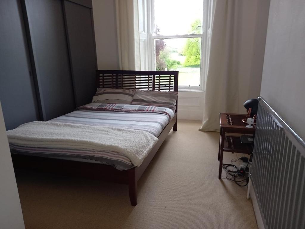 a small bed in a room with a window at Gardenvale Manor House B&B in Stranocum