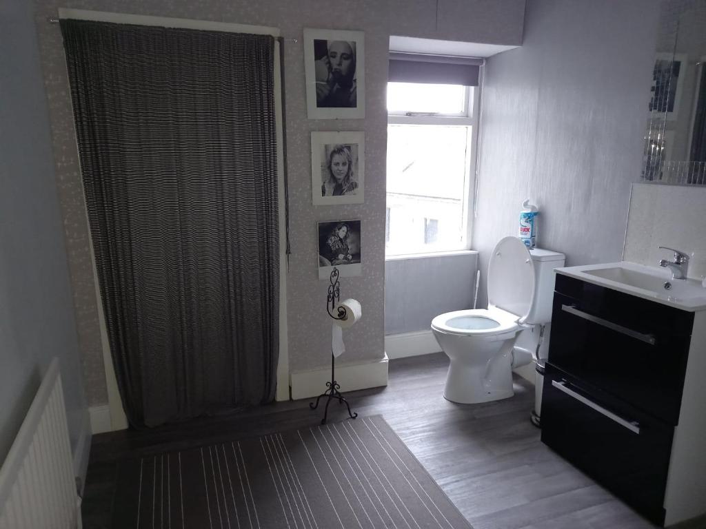 a bathroom with a toilet and a sink and a window at Gardenvale Manor House B&B in Stranocum