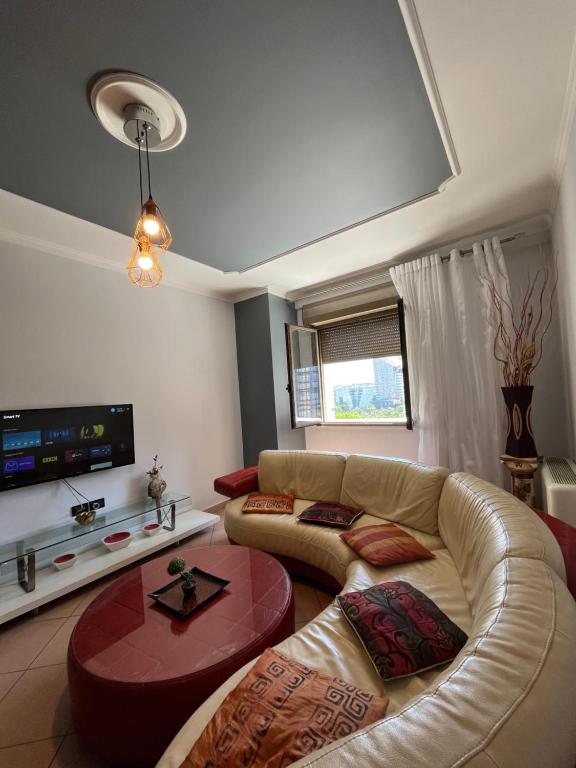 ein Wohnzimmer mit einem Sofa und einem TV in der Unterkunft Skanderbeg Square EXPLORER APARTMENTS in Tirana