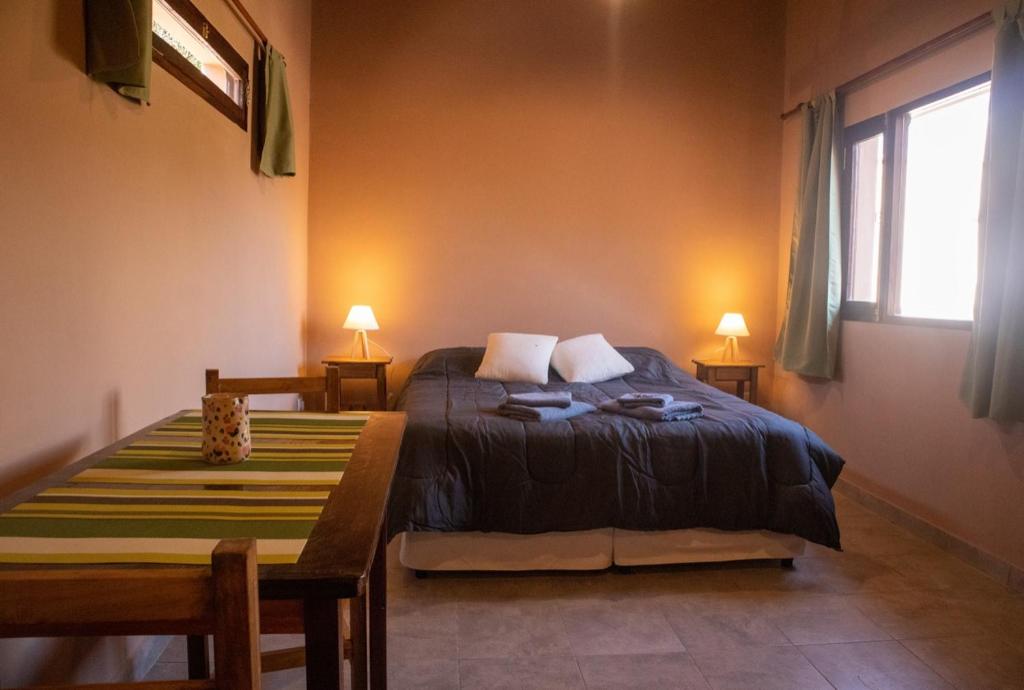 a bedroom with a bed and a table with two lamps at El Aromito Hospedaje in Tilcara