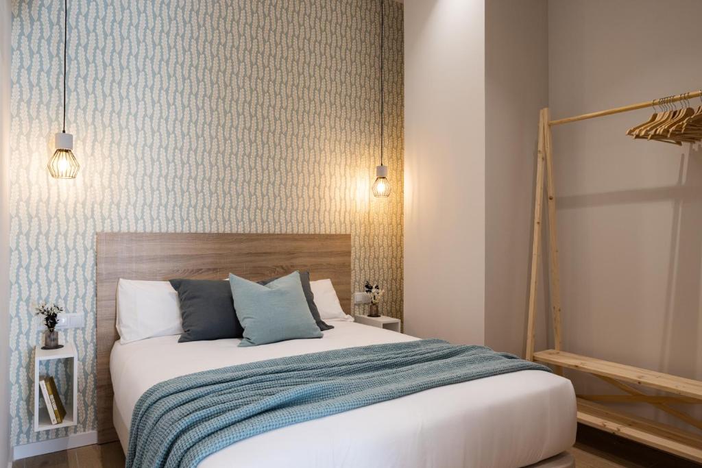 a bedroom with a large bed with blue pillows at CASA FLORIT - The Maritim Serreria Suites in Valencia