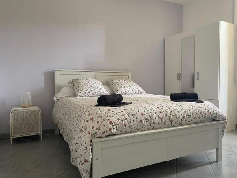 Un dormitorio con una cama blanca con dos sombreros. en Les Palmiers, en Millau