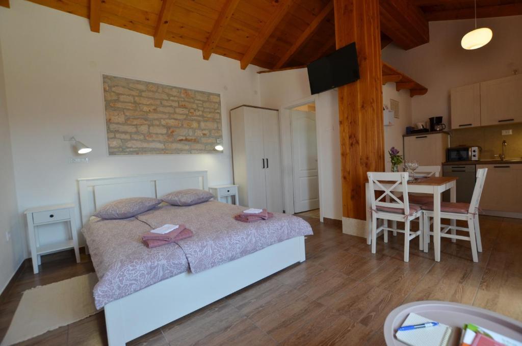 sypialnia z łóżkiem i stołem oraz kuchnia w obiekcie Casa Nini w Rovinj