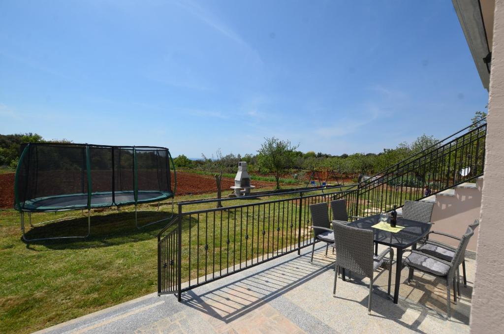 patio ze stołem, krzesłami i trampoliną w obiekcie Casa Nini w Rovinj
