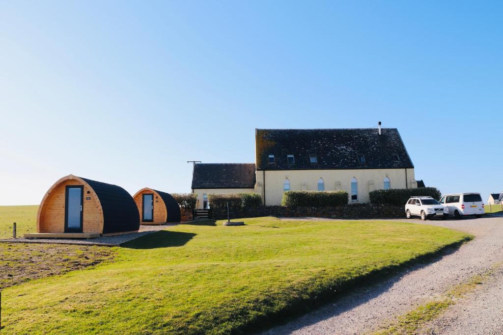 eine Gruppe von Hütten auf einem Feld neben einer Straße in der Unterkunft Kirkapol Beach Pod - Ebb in Middleton