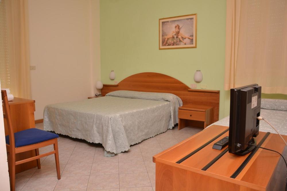 - une chambre avec un lit et une télévision sur une table dans l'établissement Hotel Velino, à Le Marmore