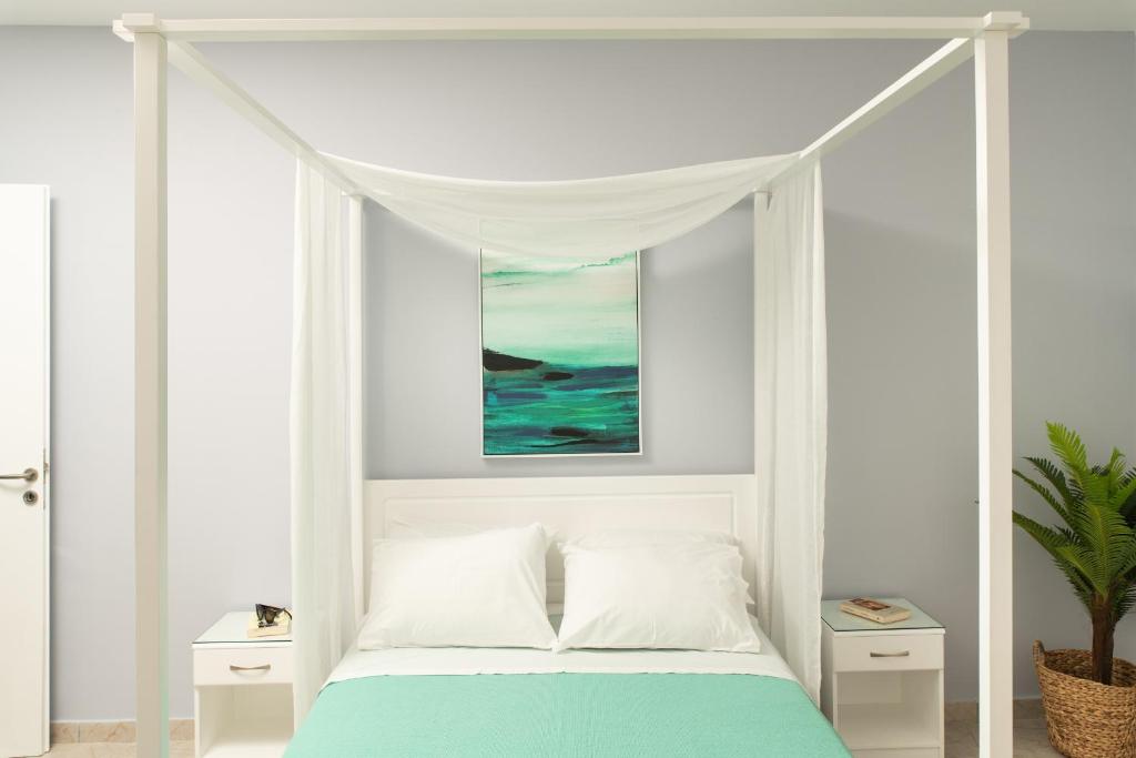 a white bed with a canopy in a bedroom at ''Meraviglia casa'' Ariadne in Kato Daratso