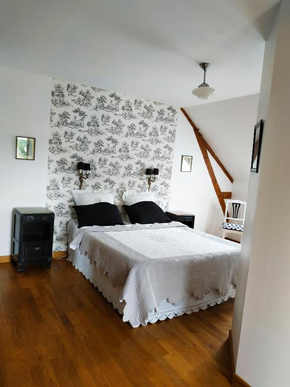 a bedroom with a white bed with a patterned wall at La loge in Menetou-Salon