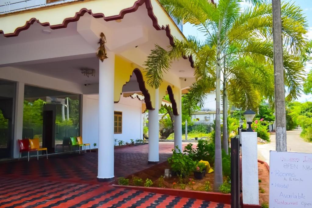 Blick auf die Veranda eines Hauses mit Palmen in der Unterkunft Hotel Theevanni Inn in Trincomalee