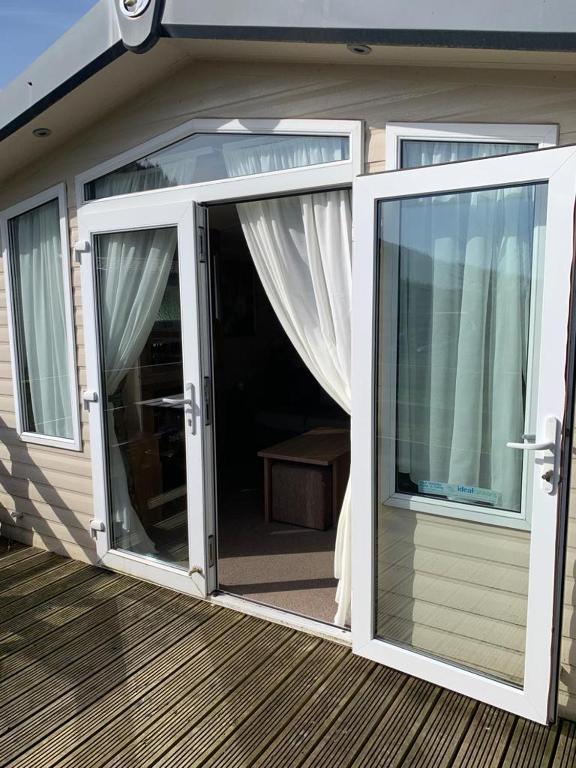 an open sliding glass door on a deck at Swift bordeaux 24 in Dunoon