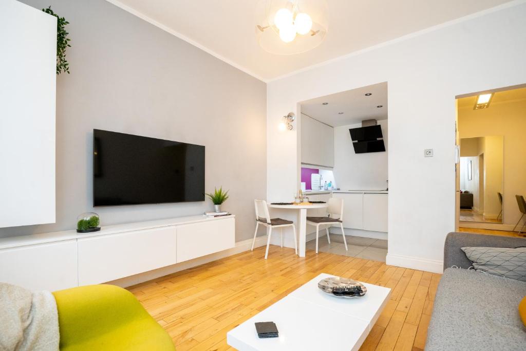 a living room with a large flat screen tv at Le Cwtch - Beautiful 1 bed boutique apartment in Cardiff