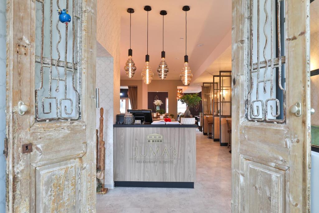 eine Lobby mit Holztüren und eine Bar in der Mitte in der Unterkunft Hotel JUMAs in Bad Zwischenahn