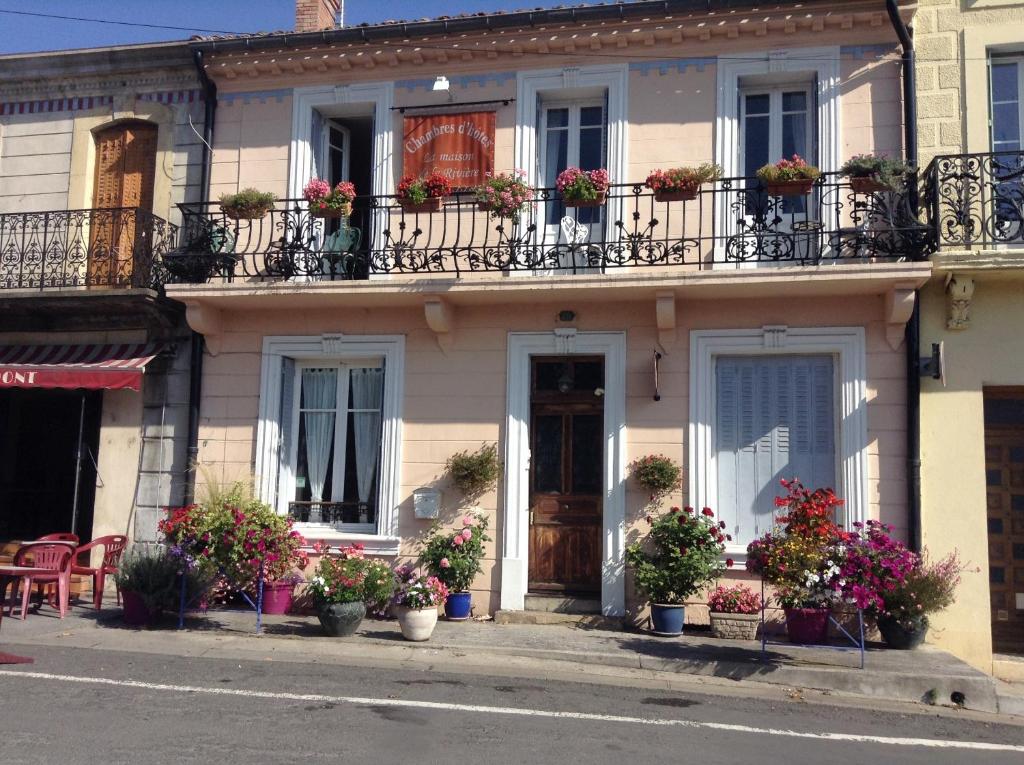 a house with potted plants on the balconies at La Maison de la Riviere B&B in Espéraza
