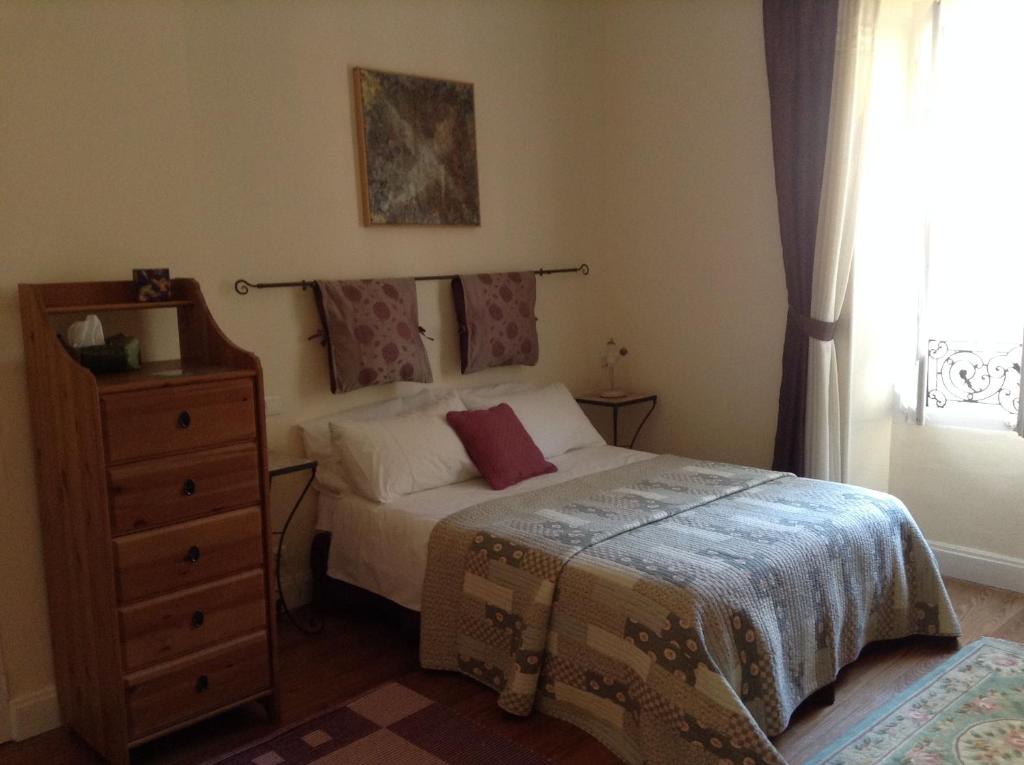 a bedroom with a bed and a dresser and a window at La Maison de la Riviere B&amp;B in Espéraza