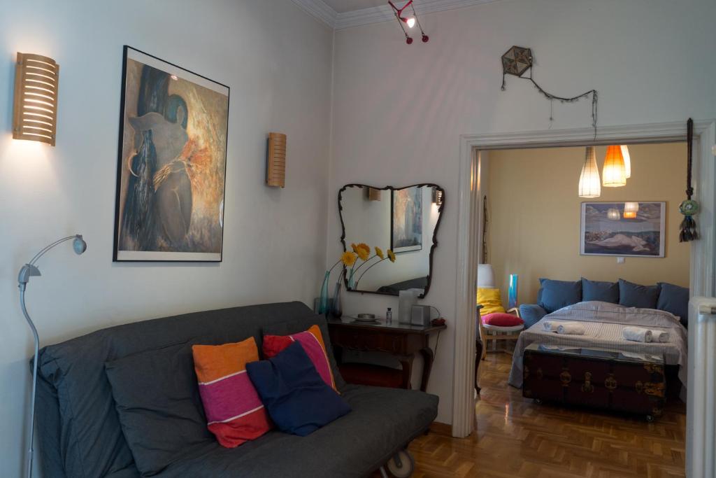 uma sala de estar com um sofá e um espelho em My Home at Koukaki em Atenas