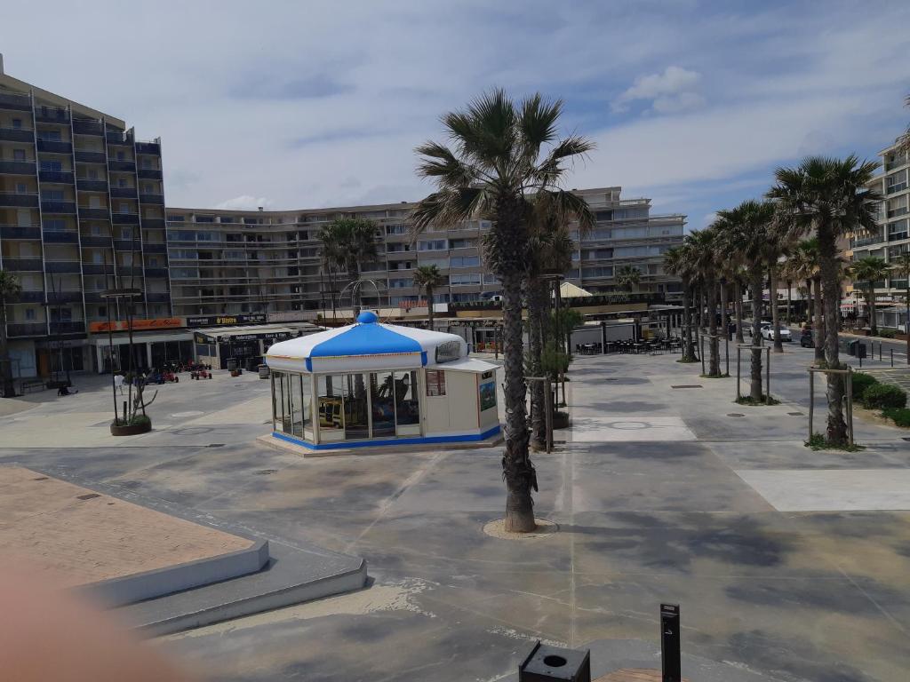 - un kiosque dans un parking avec des palmiers dans l'établissement IPANEMA - Canet en Roussillon - Vue mer - 41 m², à Canet