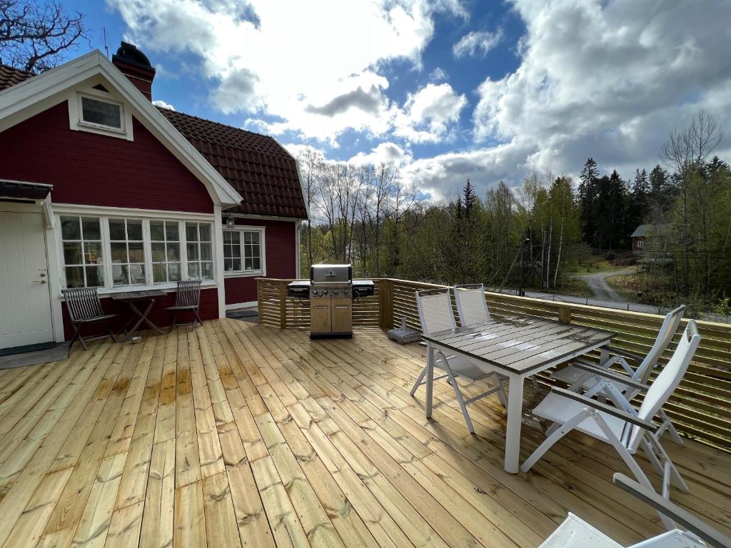 a wooden deck with a table and chairs on it at Tutviksvägen 35 in Vendelsö