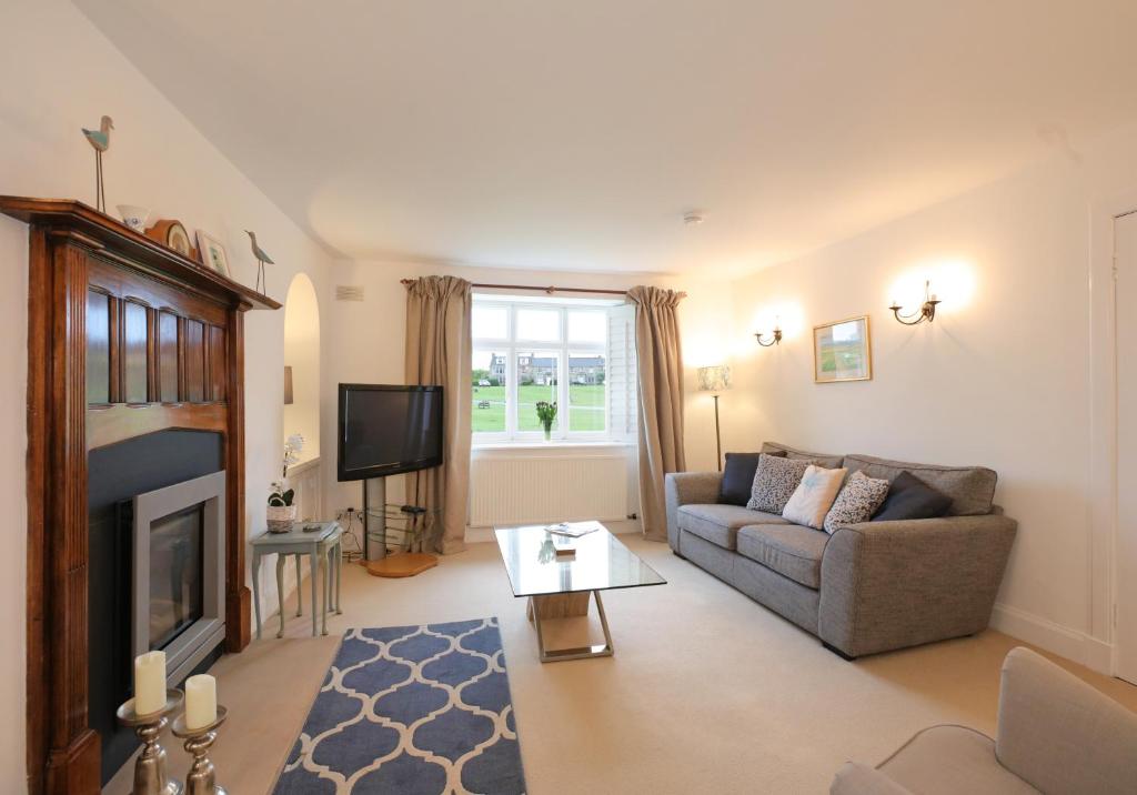 a living room with a couch and a fireplace at Primrose Cottage in Gullane