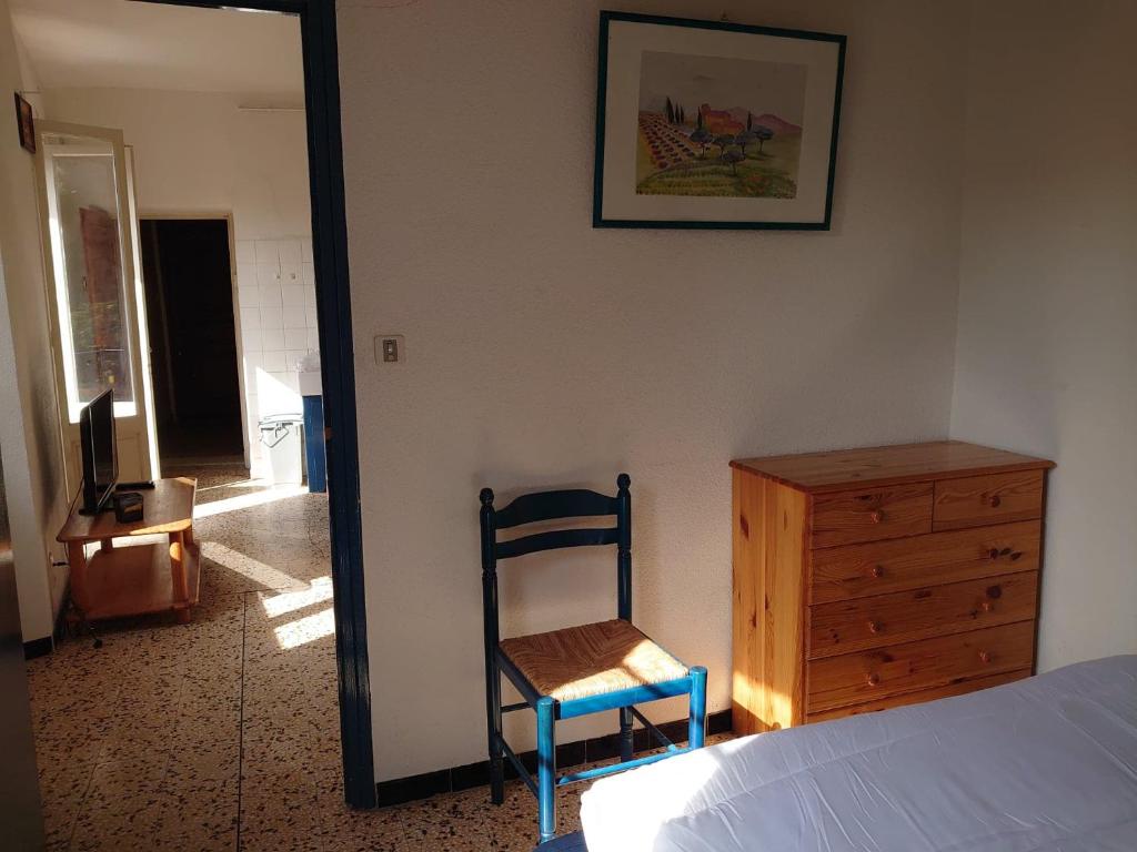 a bedroom with a bed and a chair and a dresser at 5COMA2 Appartement proche plage in Collioure
