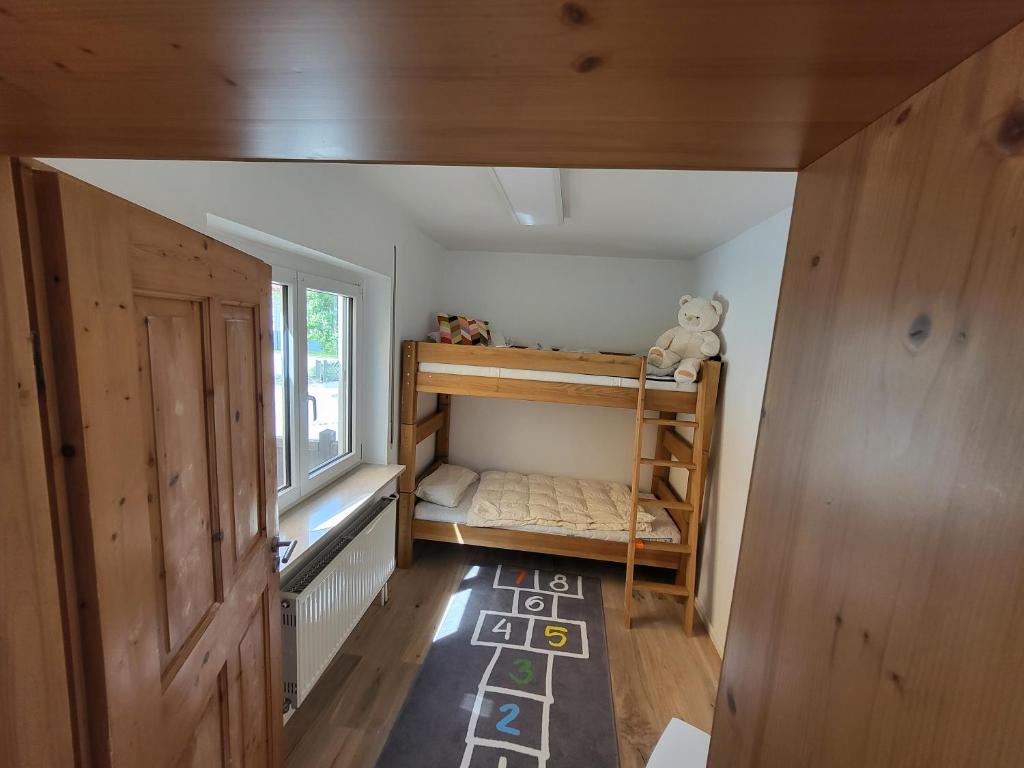 a small room with a bunk bed and a window at Family's Nest Chiemsee in Chieming