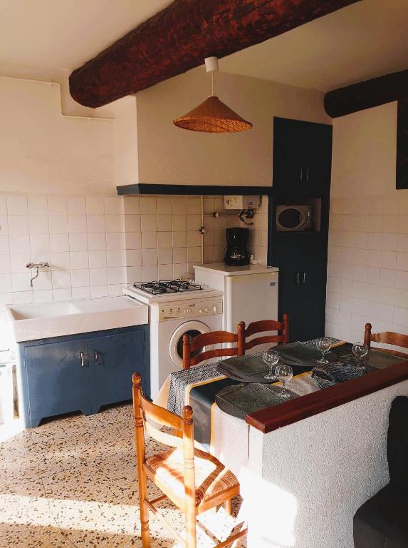 a kitchen with a stove and a table with chairs at 5COMA2 Appartement proche plage in Collioure