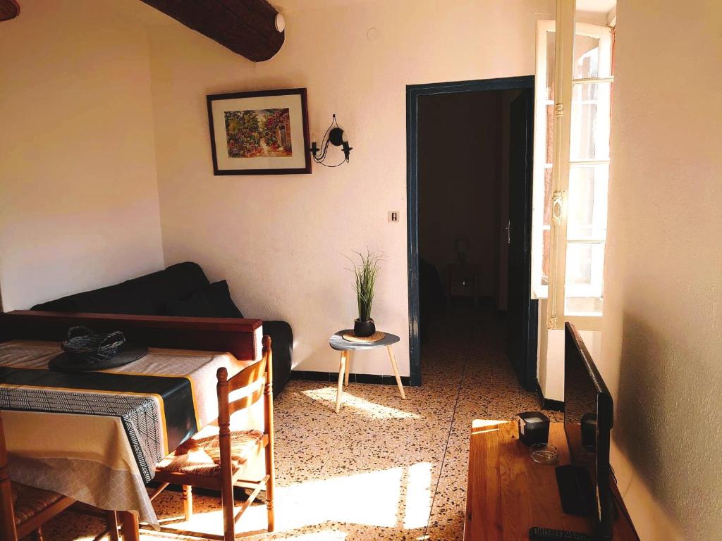 a living room with a bed and a table and a door at 5COMA2 Appartement proche plage in Collioure