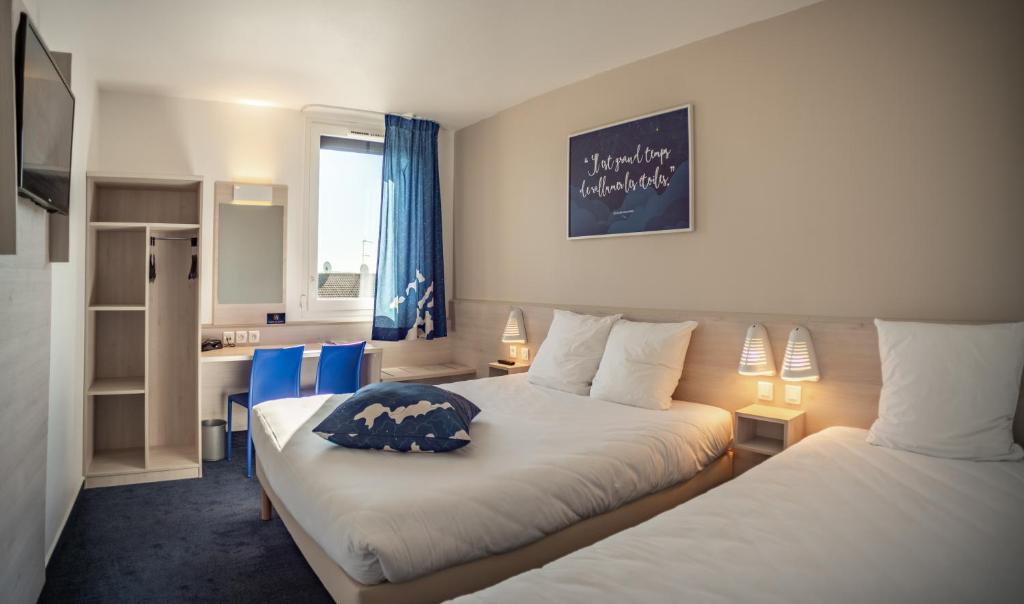 um quarto de hotel com duas camas e uma cozinha em ACE Hôtel Thionville - Porte du Luxembourg em Thionville