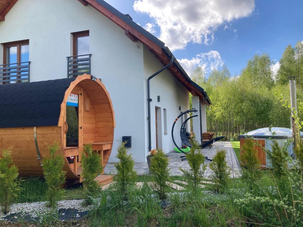 a house with a wooden archway in the yard at Willa w Brzozach Sznurki Spokojna 1 - Chmielno, Kaszuby, dom, jezioro in Chmielno