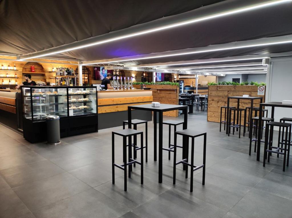 a restaurant with black tables and chairs and a bar at Boutique Hotel Nuovo Cason in Cavallino-Treporti
