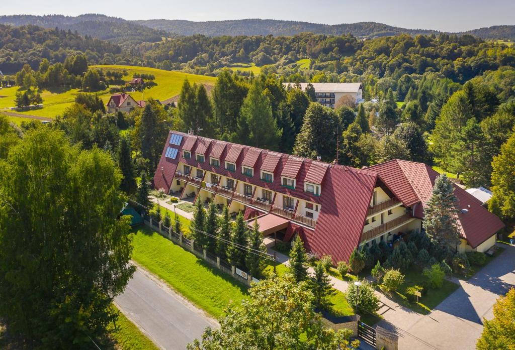 widok na budynek z czerwonym dachem w obiekcie POŁONINY Resort w mieście Bukowiec