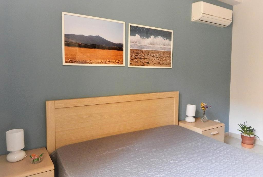- une chambre avec un lit et 2 photos sur le mur dans l'établissement Bed & Breakfast Tiziana, à Castellammare del Golfo