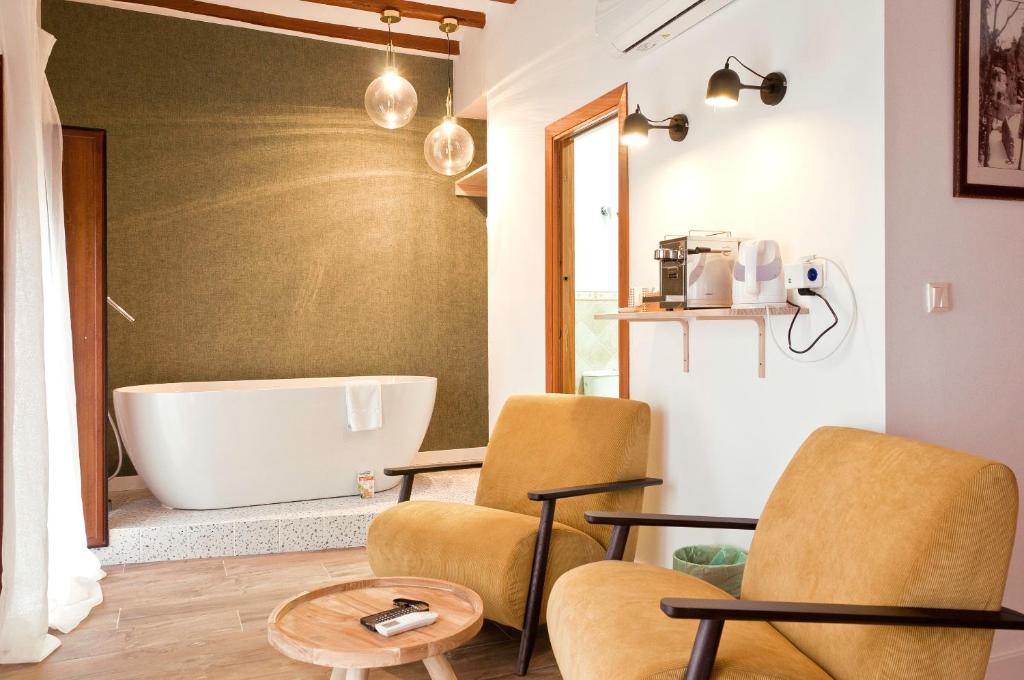 y baño con 2 sillas y bañera. en Cases Noves - Boutique Accommodation - Adults Only, en Guadalest
