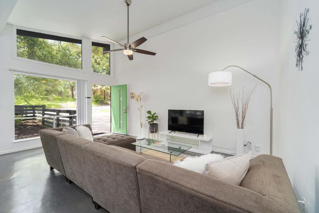 a living room with a couch and a tv at The Avocado Door - A Mid-Century Modern Gem ~ Near SoCo ~ Fenced yard ~ Corner lot in Austin
