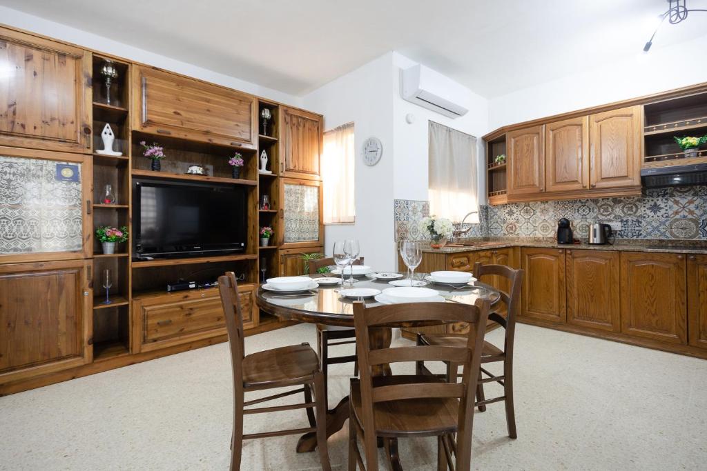 a kitchen with a table and chairs and a television at Marsalforn Apartment in Marsalforn
